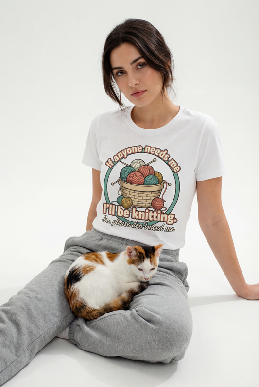 Woman wearing a t-shirt with a cat graphic and text, sitting on the floor with a cat.